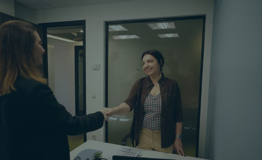 Zwei Frauen beim Handschlag – Symbolbild für legale Alternative zur Arbeitnehmerüberlassung im Ausland