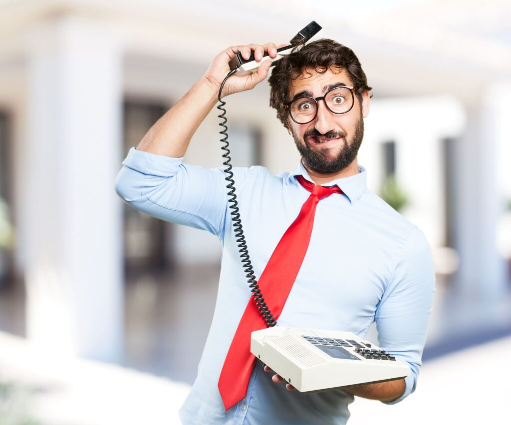 Verwirrter Mann mit Telefon im Büro – outbound call center Humor