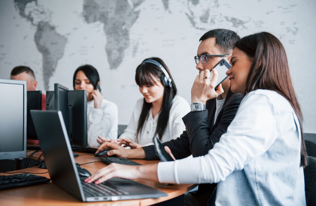 Mitarbeiter einer Telemarketing Agentur bei der Arbeit im modernen Büro