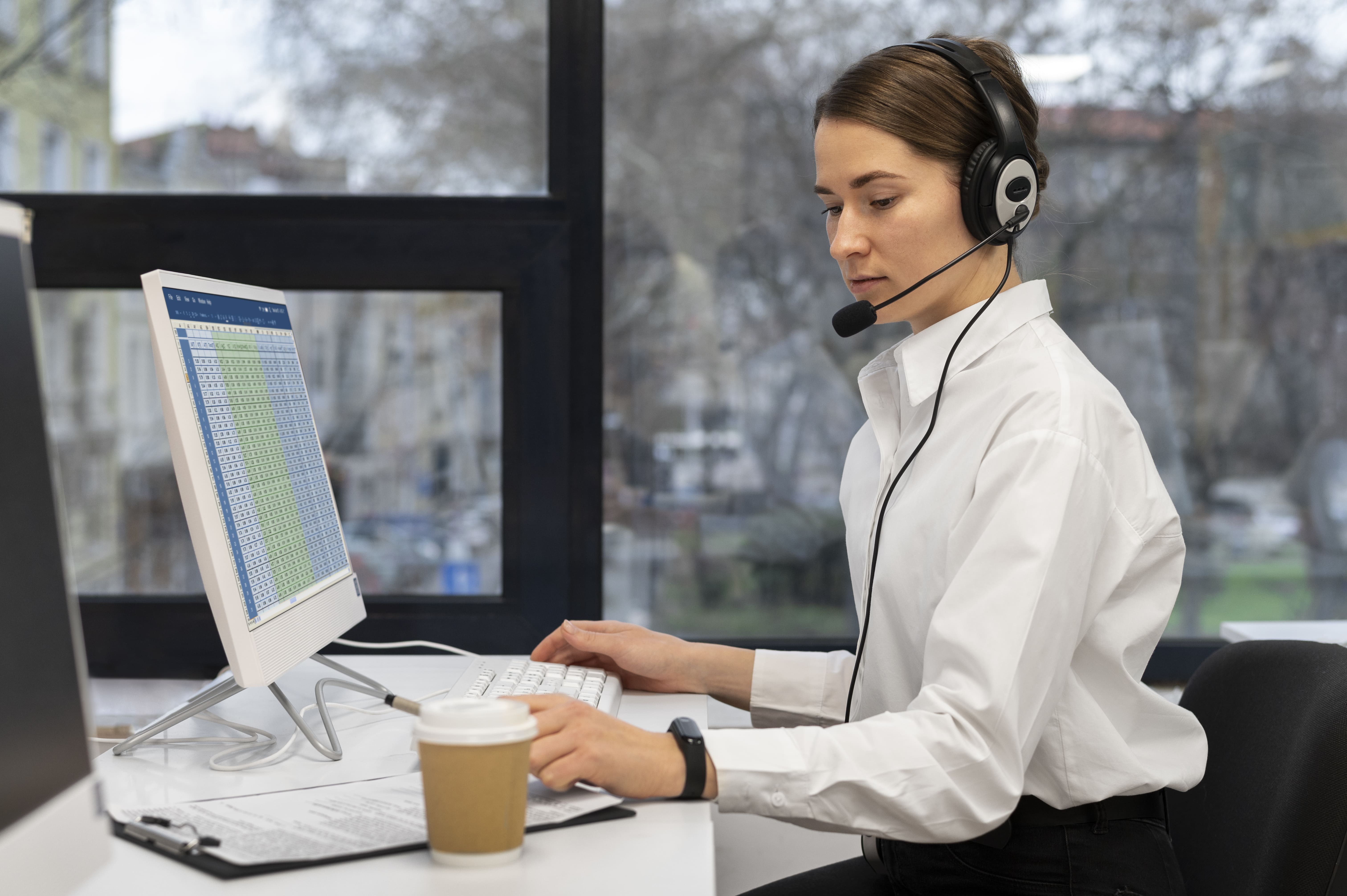 Mitarbeiterin im Inbound Call Center mit Headset am Computer