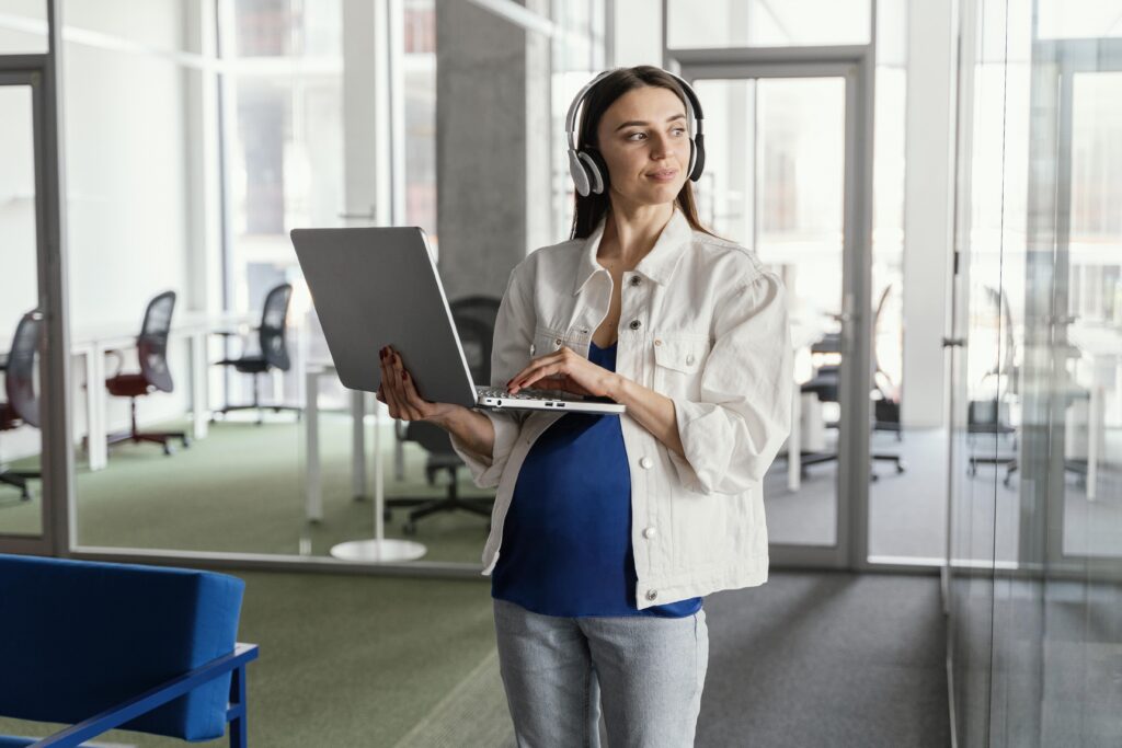 Frau mit Laptop und Kopfhörern im modernen Büro – Personal Service Provider aus Georgien