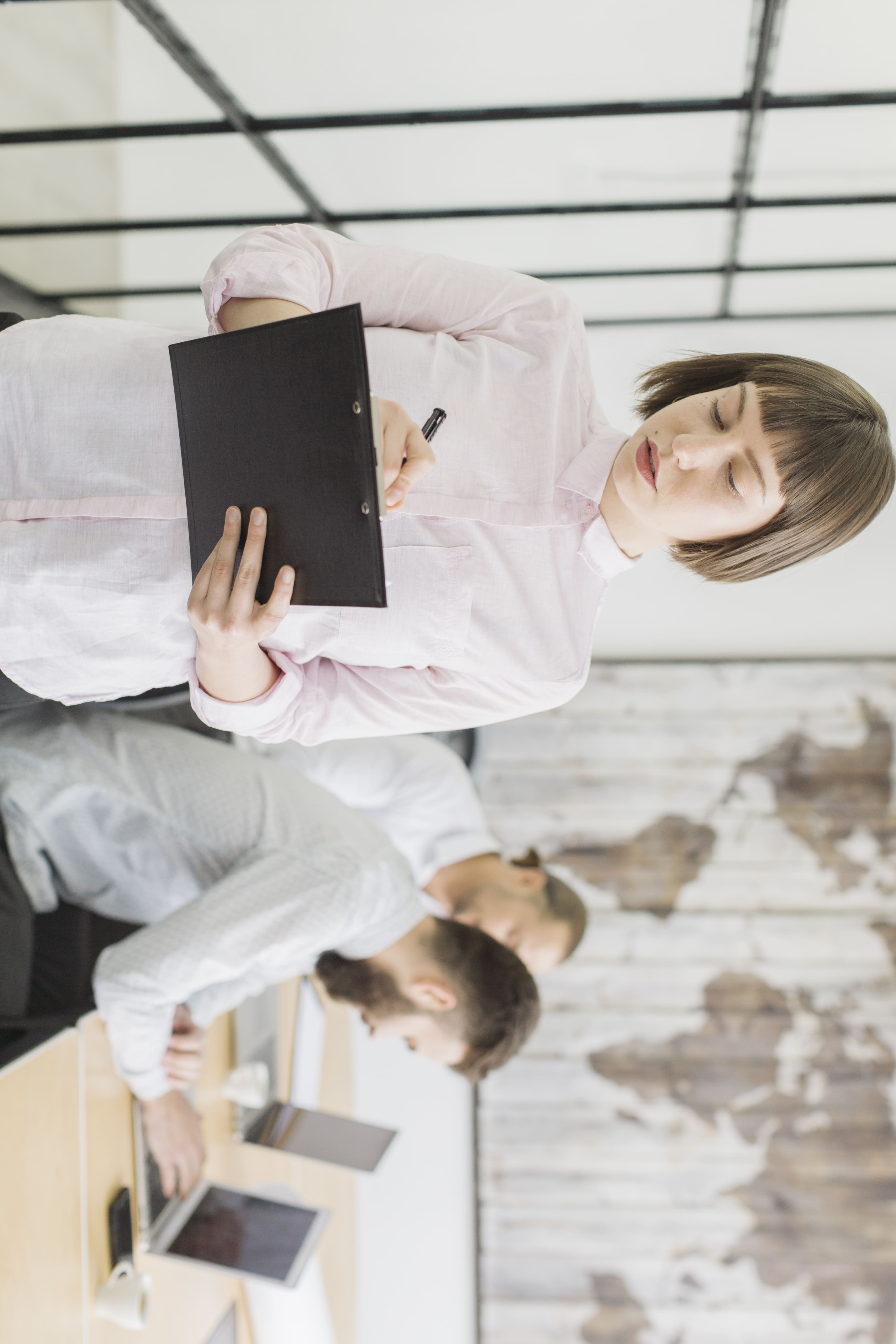 Frau mit Klemmbrett im Büro überprüft Bewerbungen – mitarbeiter einstellen Prozess in einem modernen Team