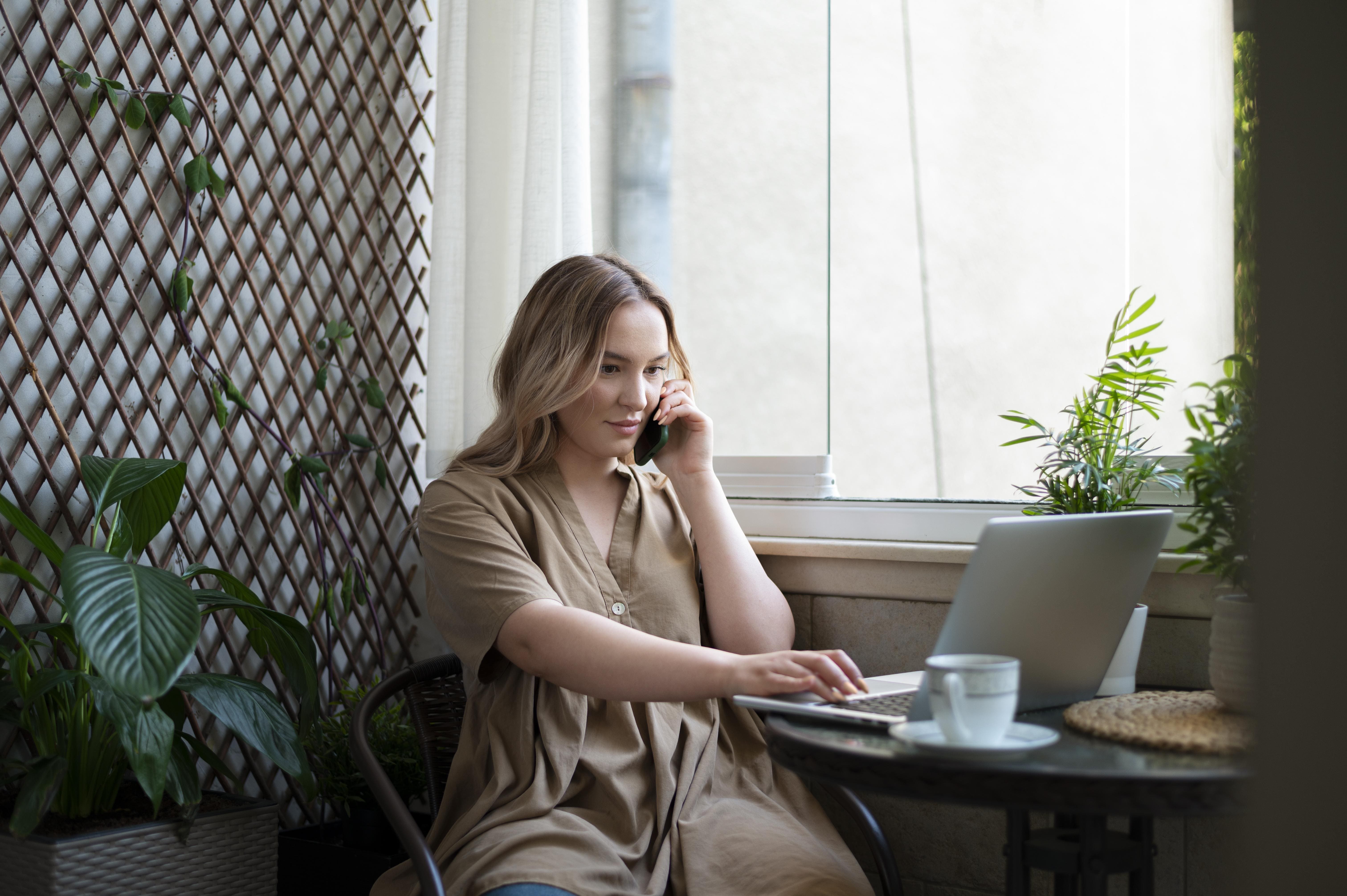 Frau arbeitet remote am Laptop und spricht am Telefon über logistic chain management